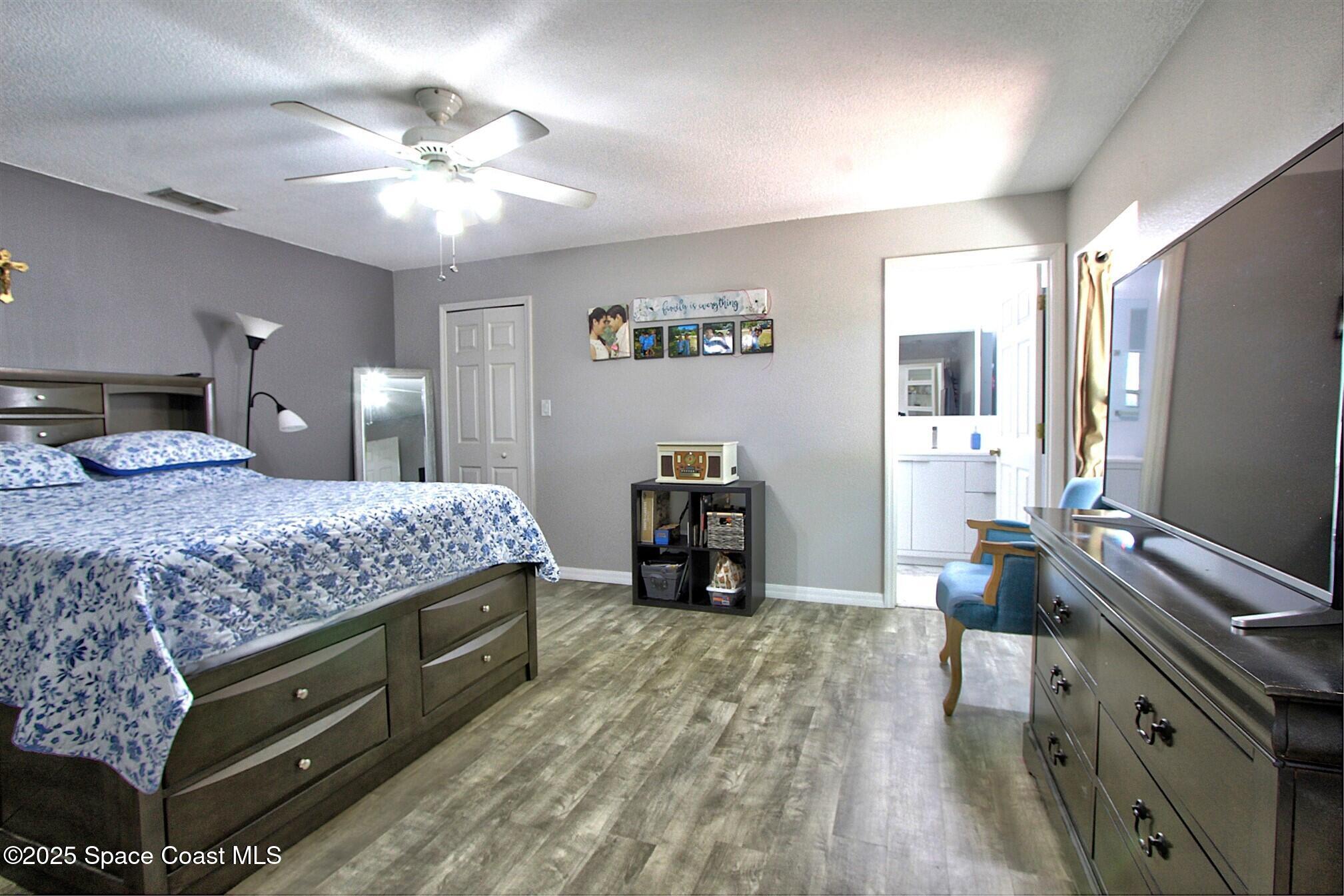 4850 Ancona Road Cocoa, FL 32927 - Photo 12 of 31 a bedroom with a bed and a chandelier