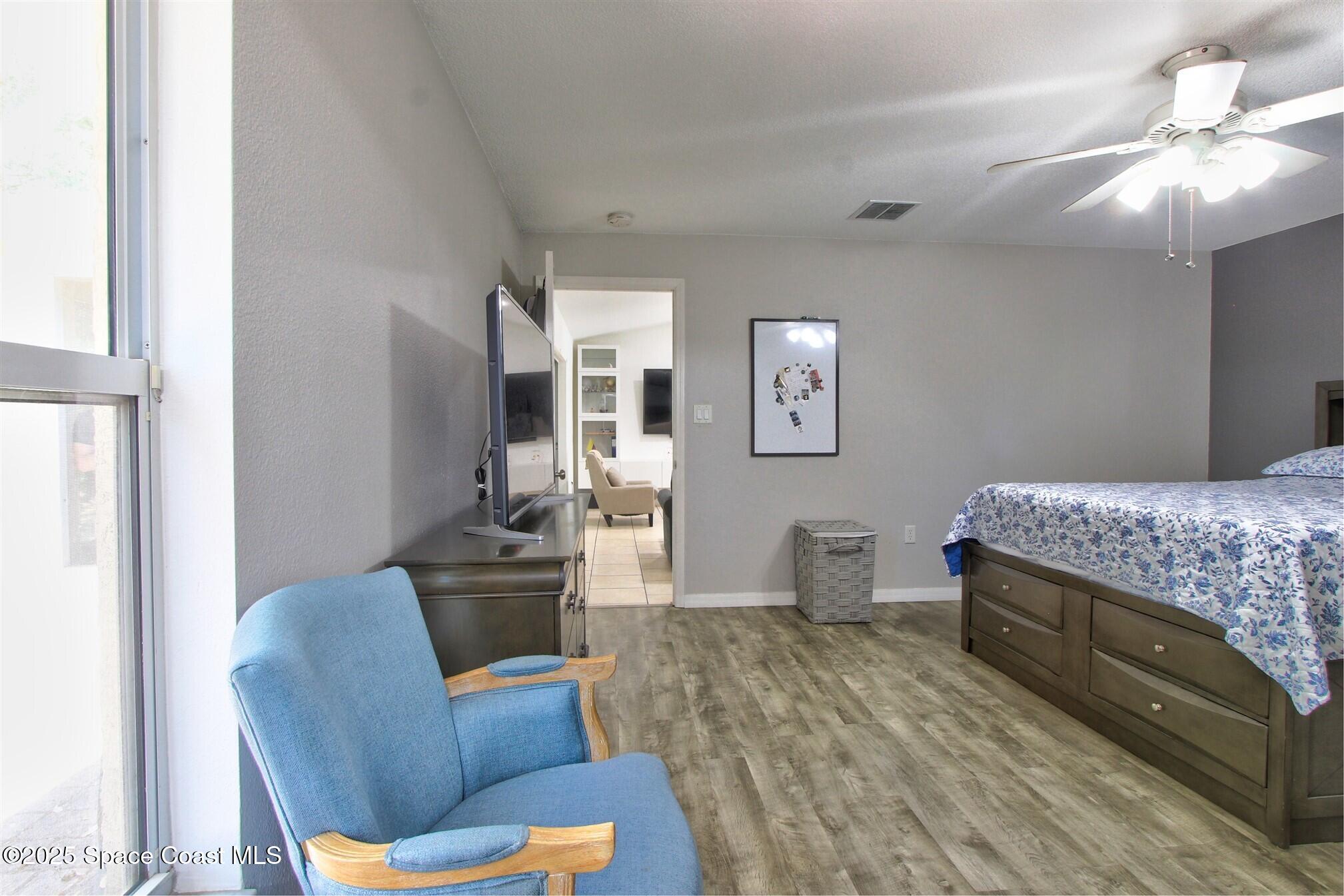 4850 Ancona Road Cocoa, FL 32927 - Photo 13 of 31 a bedroom with furniture and a wooden floor