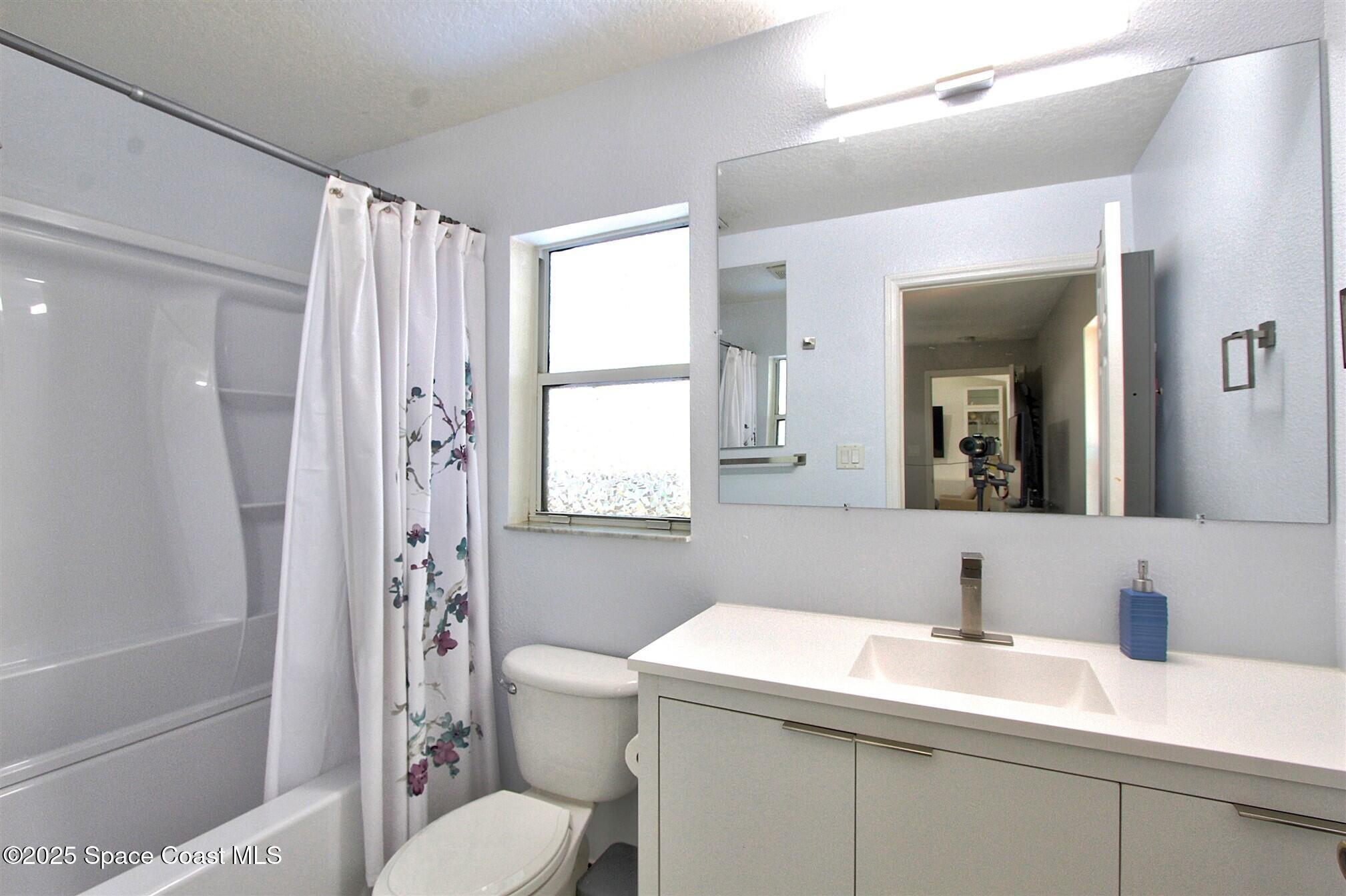 4850 Ancona Road Cocoa, FL 32927 - Photo 14 of 31 a bathroom with a sink toilet vanity and shower