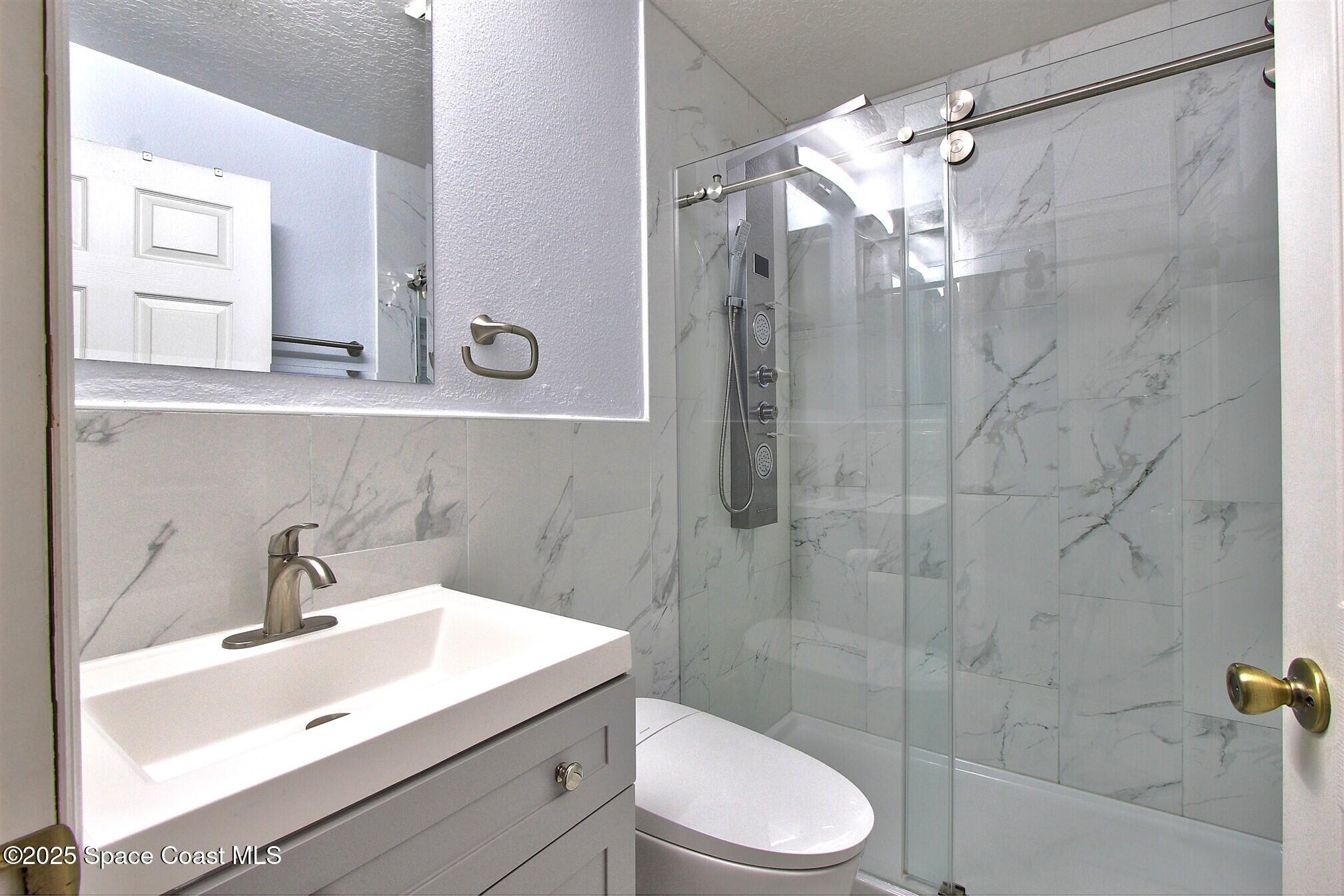 4850 Ancona Road Cocoa, FL 32927 - Photo 18 of 31 a bathroom with a sink a toilet and shower