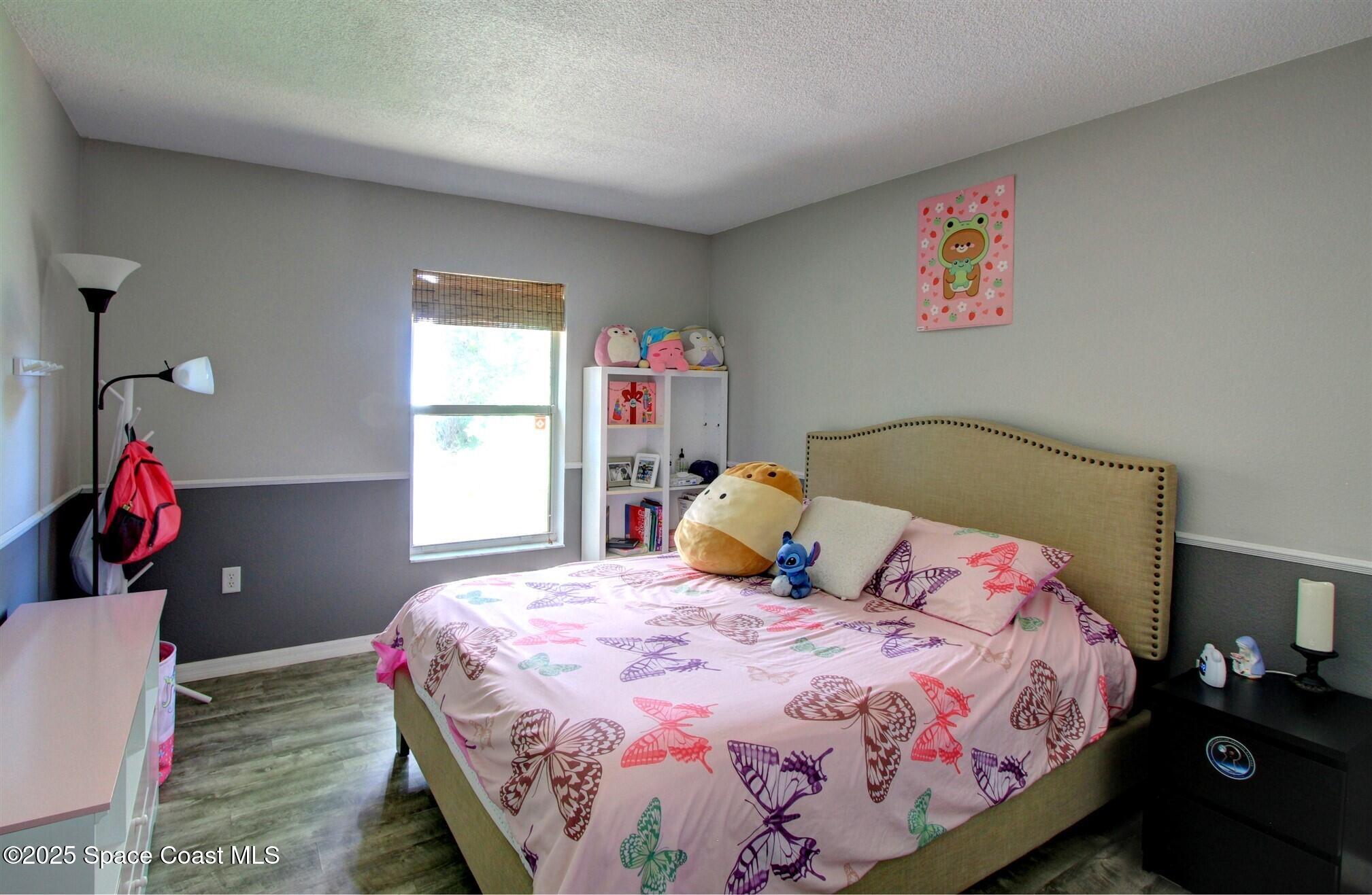 4850 Ancona Road Cocoa, FL 32927 - Photo 20 of 31 a bedroom with a bed and a chandelier