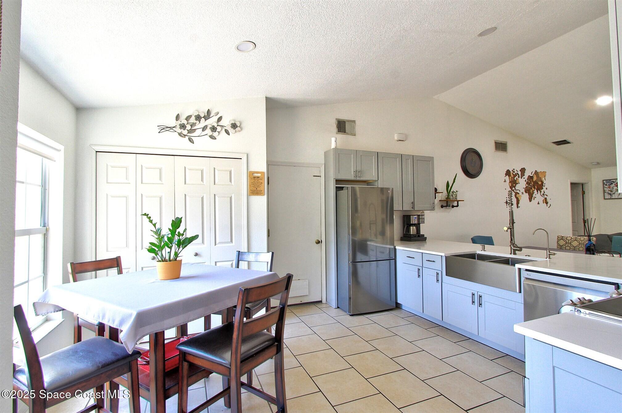 4850 Ancona Road Cocoa, FL 32927 - Photo 3 of 31 a kitchen with stainless steel appliances granite countertop a stove a sink dishwasher a refrigerator and a dining table with garden view
