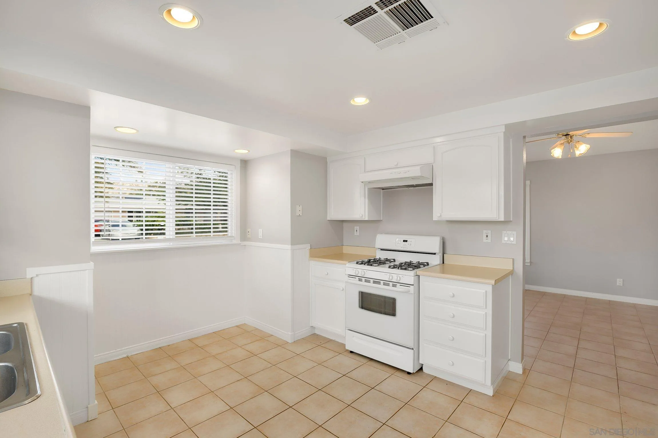 13647 Somerset Road Poway, CA 92064 - Photo 8 of 25 a kitchen with granite countertop white cabinets and white appliances