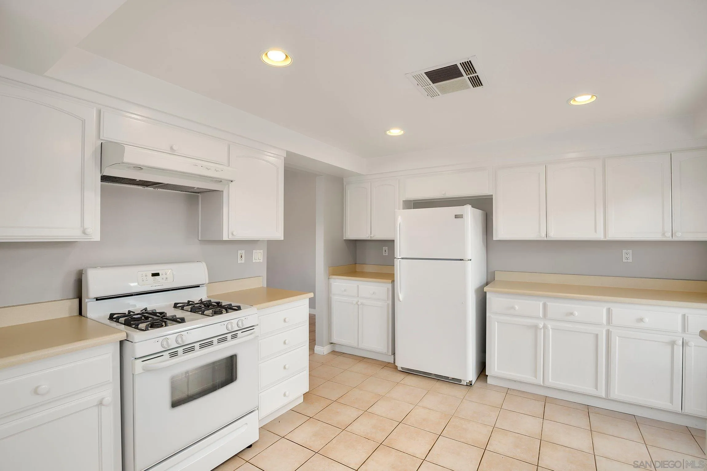 13647 Somerset Road Poway, CA 92064 - Photo 9 of 25 a kitchen with white cabinets and white appliances