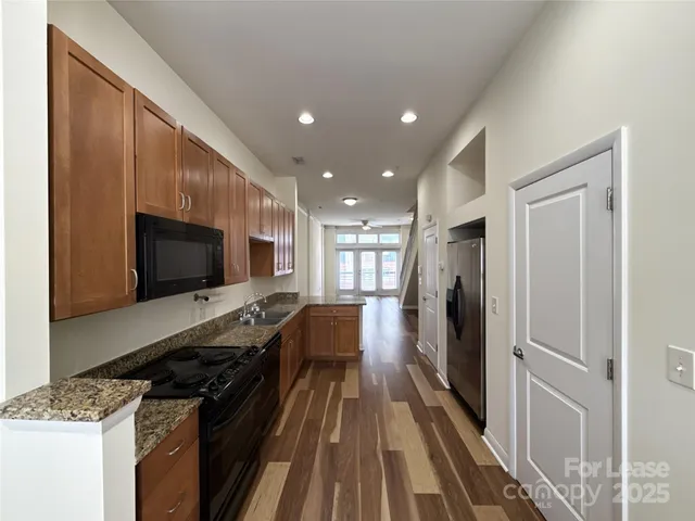 a kitchen with stainless steel appliances granite countertop a stove refrigerator and a microwave