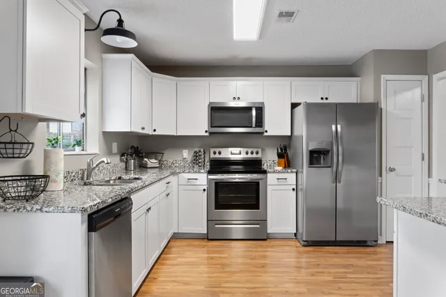 a kitchen with granite countertop a refrigerator and stove