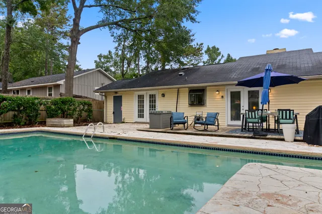 a view of a patio with table and chairs under an umbrella