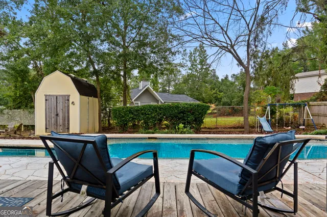 a front view of a house with swimming pool having outdoor seating