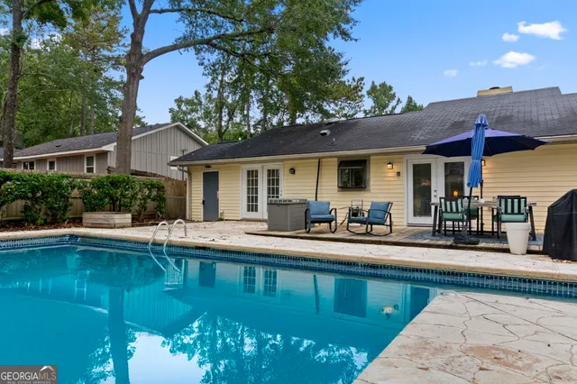 a view of a patio with table and chairs under an umbrella