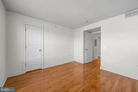 a view of empty room with wooden floor