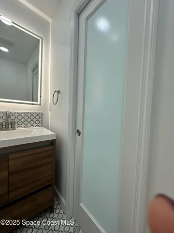 a bathroom with a sink a toilet a mirror and shower