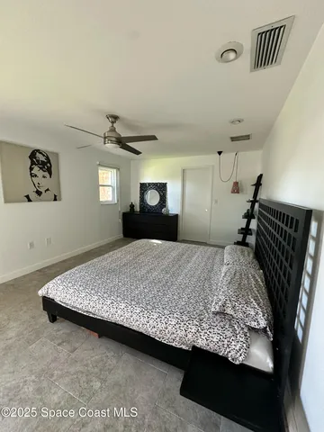 a bed sitting in a bedroom next to a window