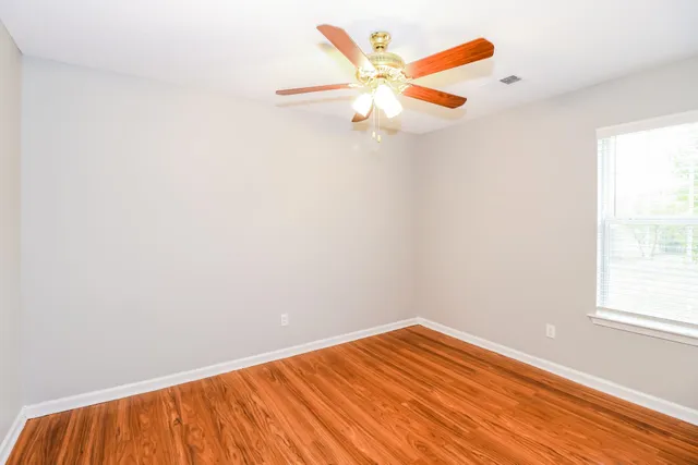 a view of a room with wooden floor and fan