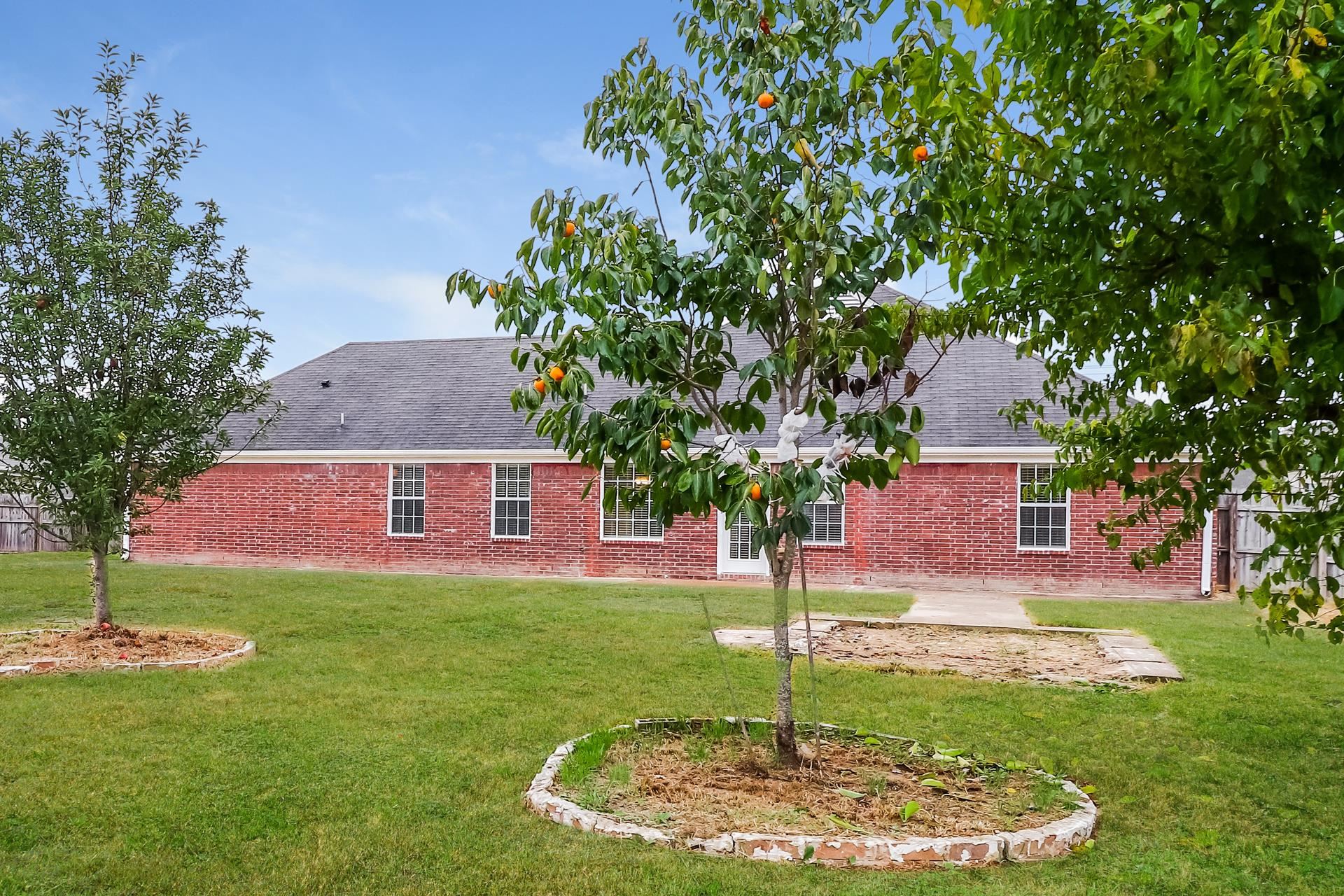 2415 North Forest Hill Irene Road Cordova, TN 38016 - Photo 15 of 16 Rear view of property featuring a patio, roof with shingles, a lawn, and brick siding