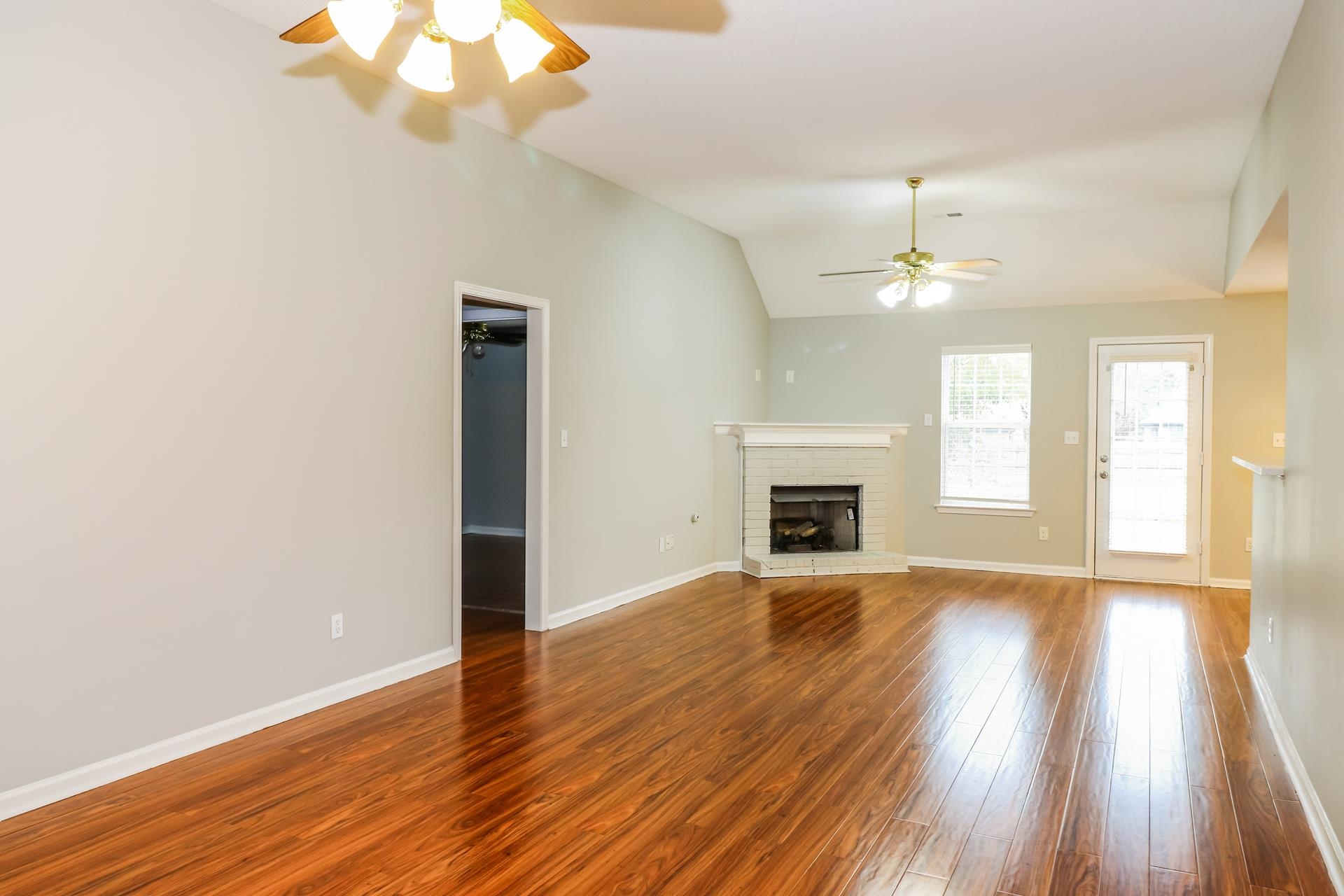 2415 North Forest Hill Irene Road Cordova, TN 38016 - Photo 3 of 16 Unfurnished living room featuring wood finished floors, lofted ceiling, a fireplace, and ceiling fan