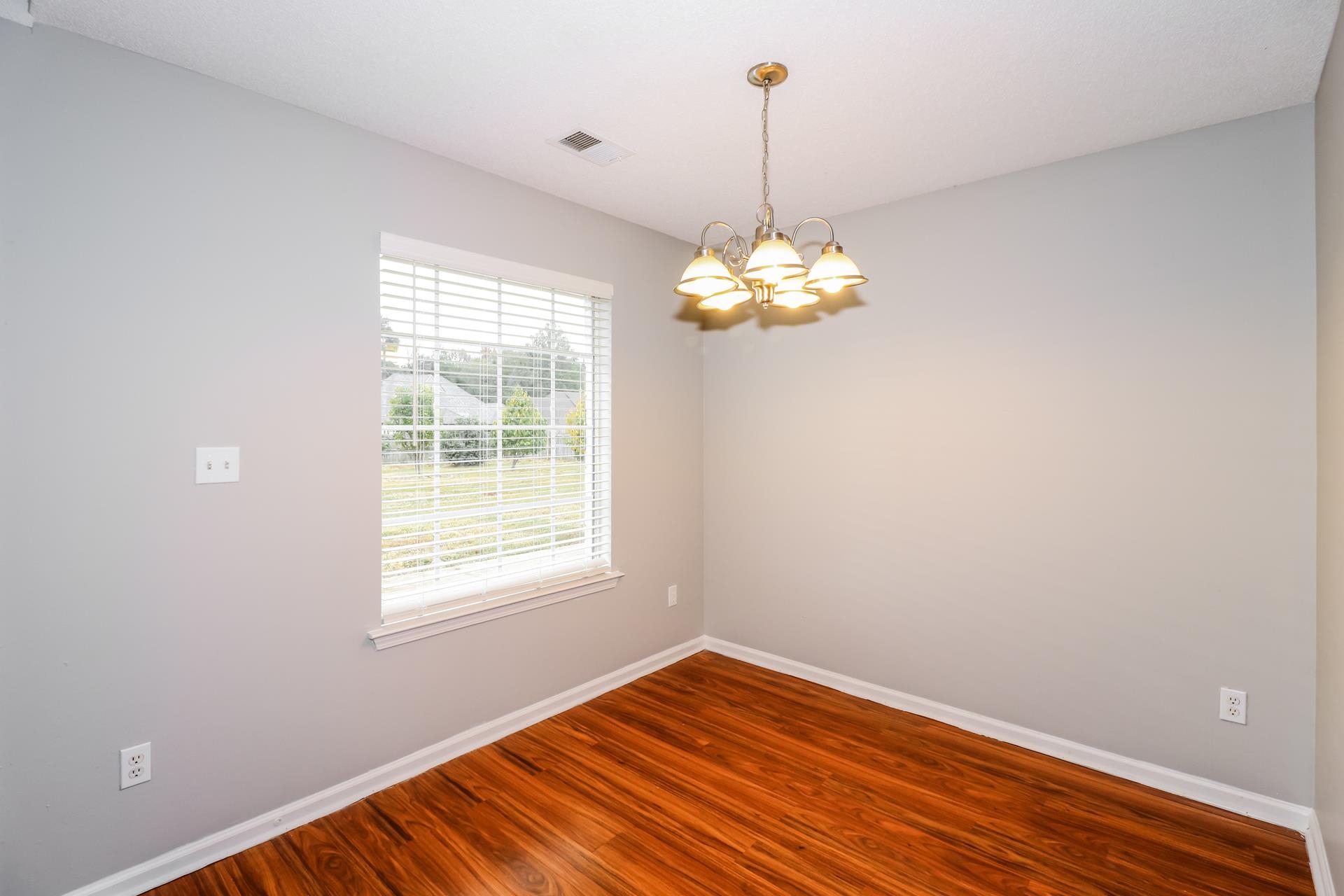 2415 North Forest Hill Irene Road Cordova, TN 38016 - Photo 5 of 16 Spare room with wood finished floors and a chandelier