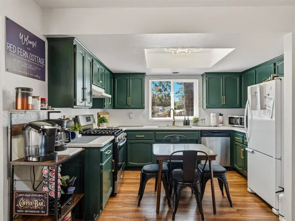 a kitchen with a table chairs refrigerator and cabinets