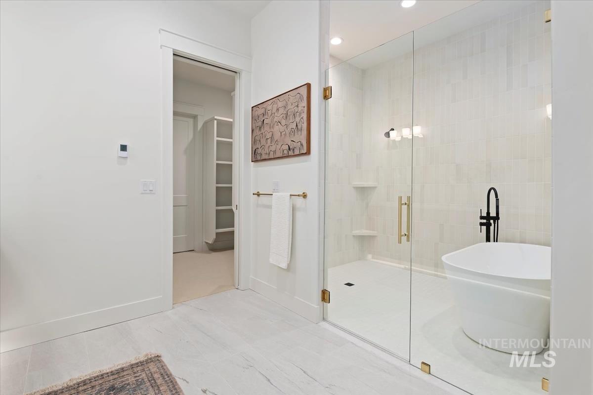 196 North Timber Wolf Place Eagle, ID 83616 - Photo 24 of 50 Bathroom featuring a stall shower, a spacious closet, a freestanding tub, and recessed lighting