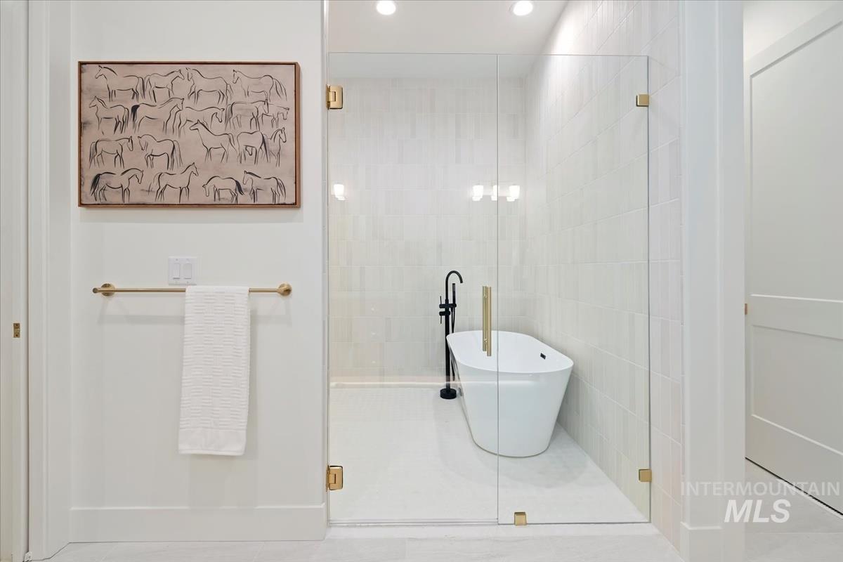 196 North Timber Wolf Place Eagle, ID 83616 - Photo 25 of 50 Bathroom featuring a shower stall, a soaking tub, tile walls, recessed lighting, and tile patterned flooring