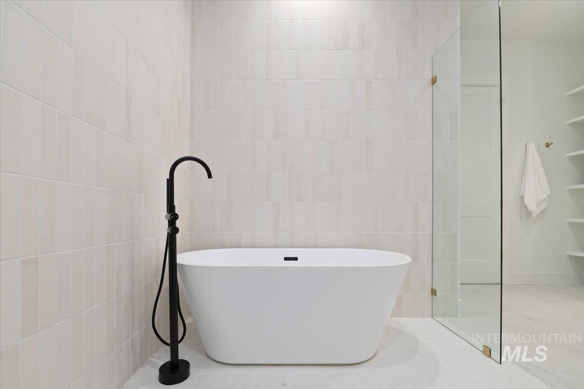 196 North Timber Wolf Place Eagle, ID 83616 - Photo 26 of 50 Full bathroom with a freestanding bath, tile walls, and a shower