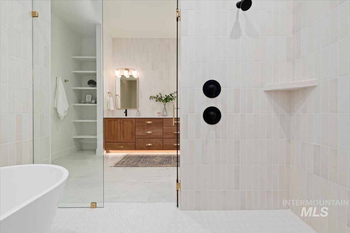 196 North Timber Wolf Place Eagle, ID 83616 - Photo 27 of 50 Full bathroom featuring walk in shower, vanity, tile walls, a freestanding bath, and built in features