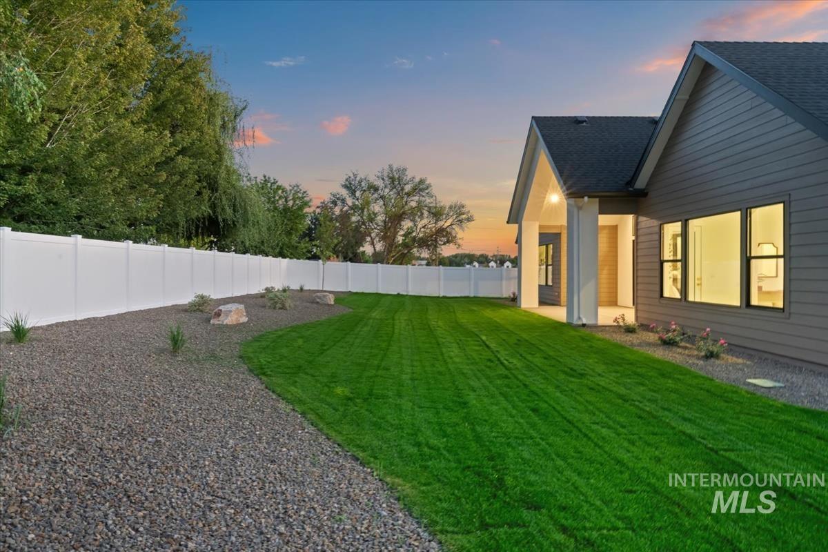 196 North Timber Wolf Place Eagle, ID 83616 - Photo 48 of 50 Yard at dusk featuring a patio area and a fenced backyard