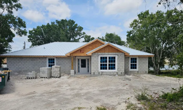 a front view of house with yard and trees around