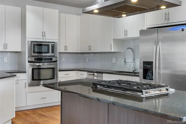 a kitchen with granite countertop a stove and a refrigerator