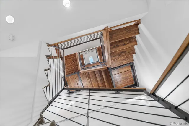 a view of staircase with white walls and railing