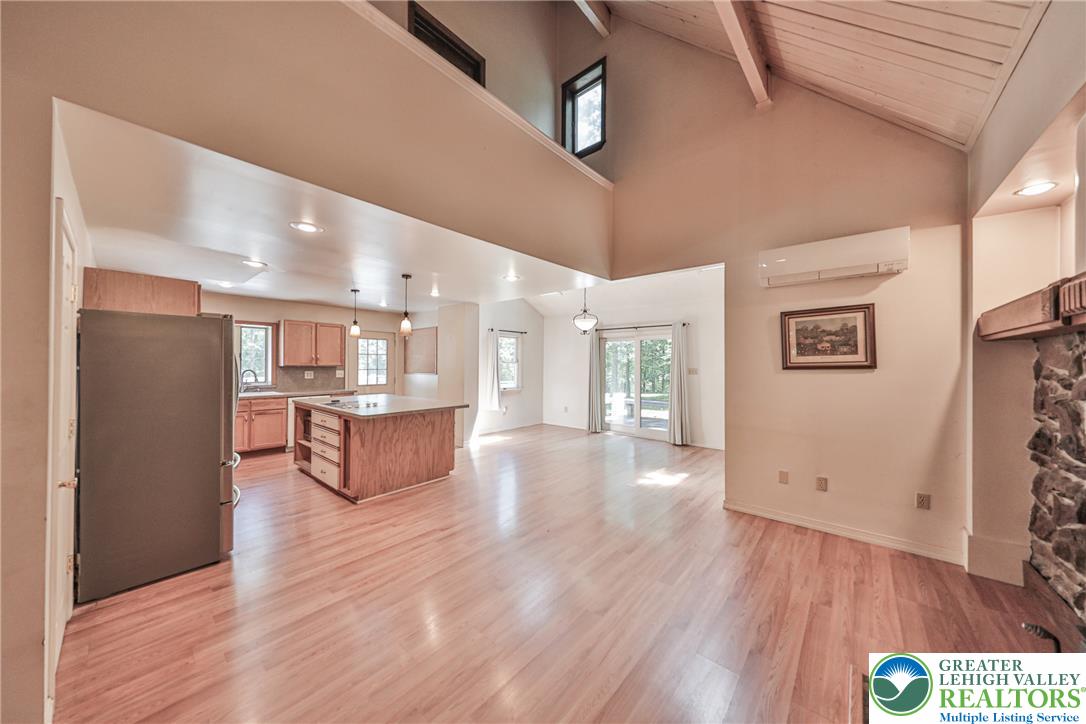 152 Inverhouse Road Henryville, PA 18332 - Photo 18 of 64 An inviting open-concept space features vaulted wood ceilings and a functional kitchen island, perfect for gathering.