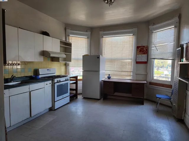 a kitchen with granite countertop a refrigerator and a stove