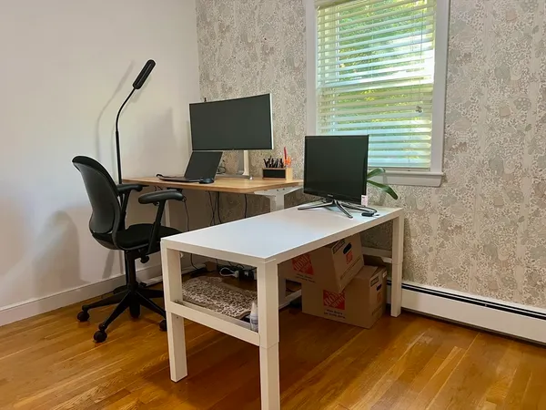 a view of a workspace with furniture and a window