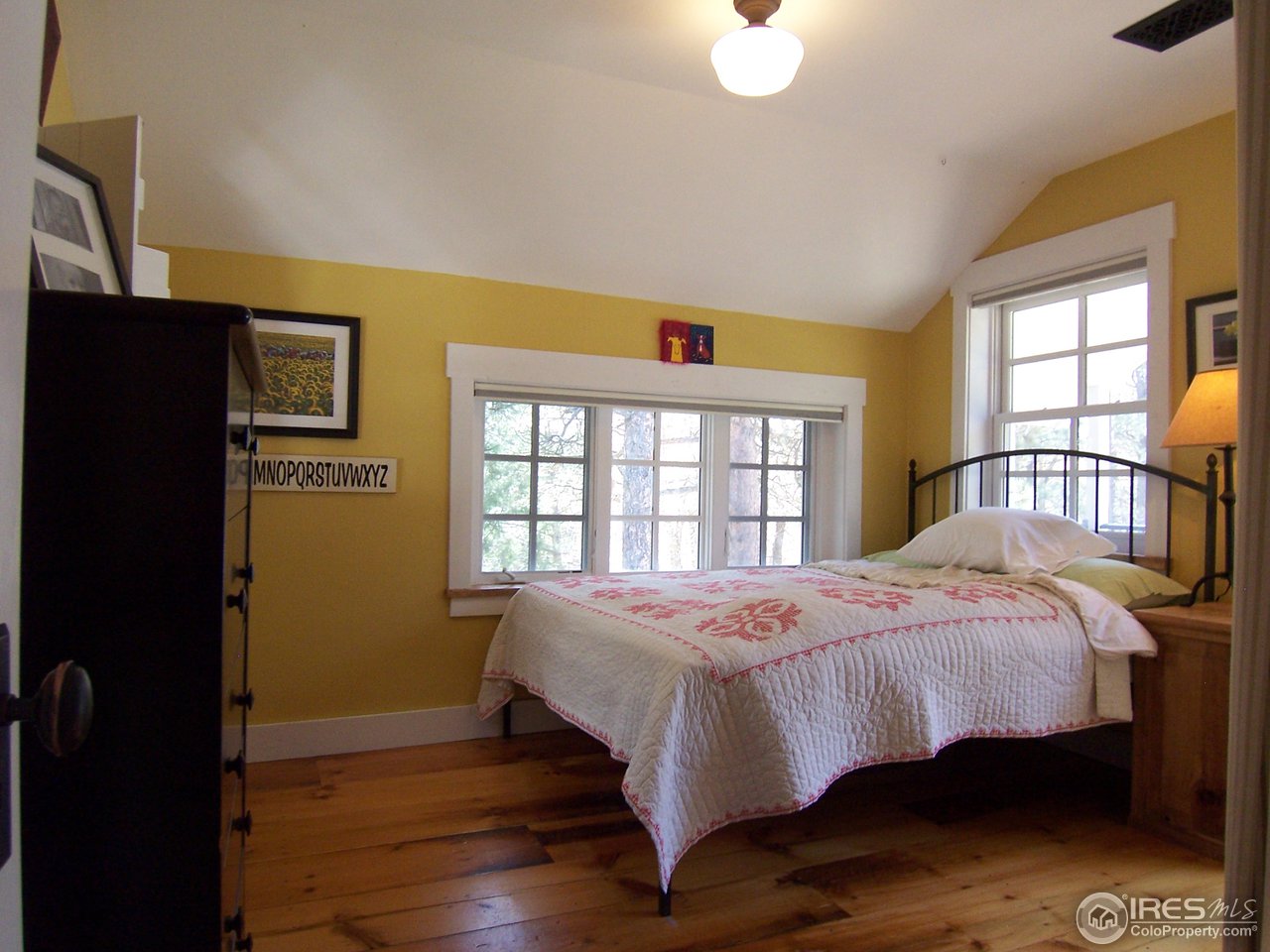459 Gold Run Road Boulder, CO 80302 - Photo 14 of 18 a bedroom with a bed and wooden floor