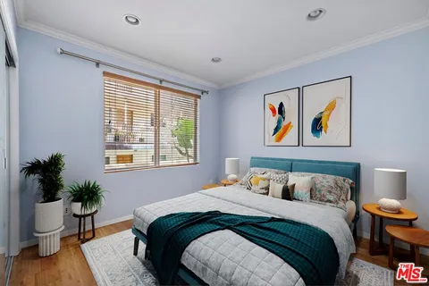 a bedroom with bed and a potted plant