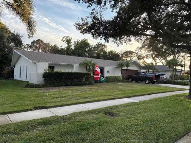 a front view of a house with a yard and trees