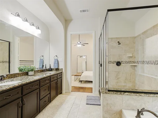 a spacious bathroom with a granite countertop sink mirror and shower