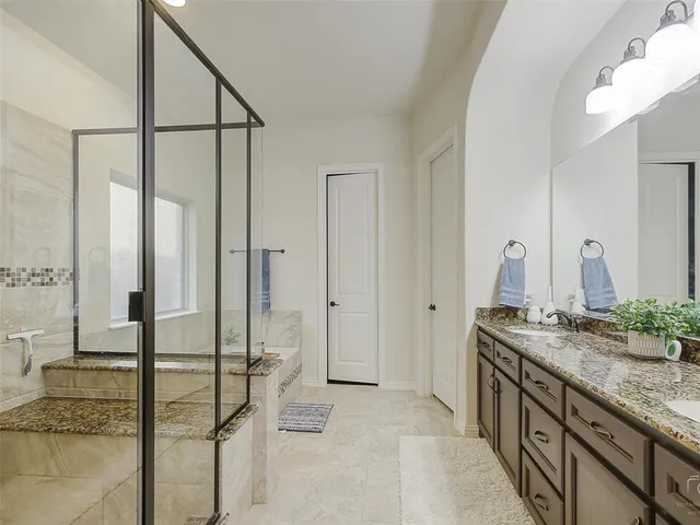 a spacious bathroom with a granite countertop sink and a mirror