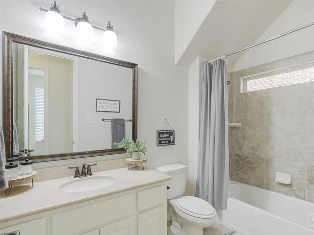 a bathroom with a granite countertop sink toilet a large mirror and shower