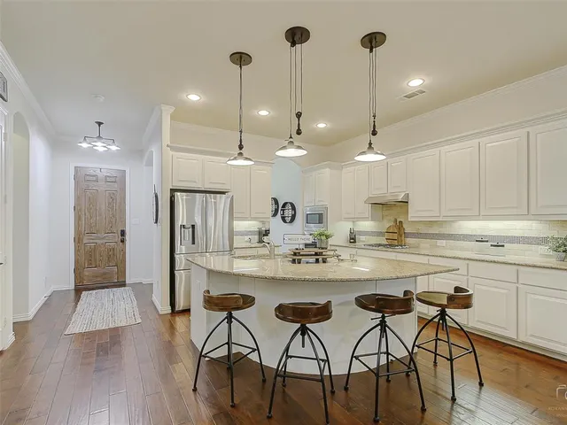 a kitchen with kitchen island a refrigerator and a sink