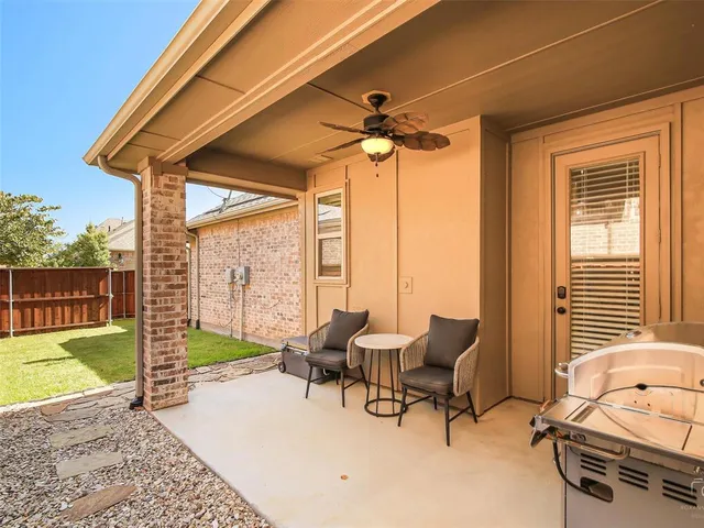 a living room with patio furniture and a floor to ceiling window