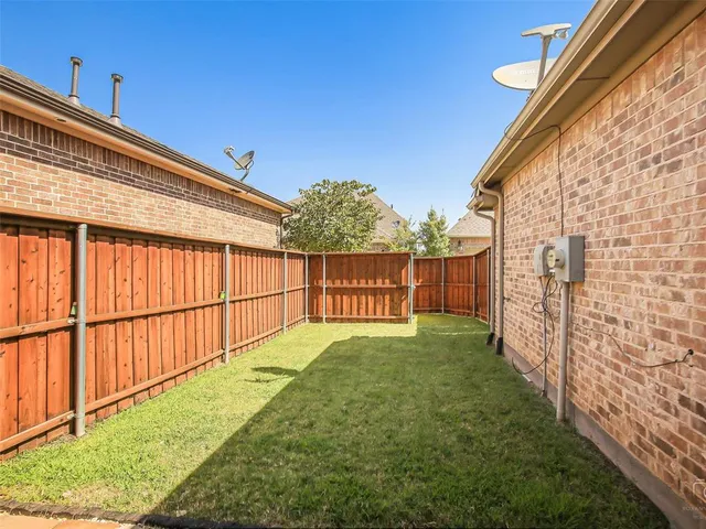 a view of backyard with wooden fence