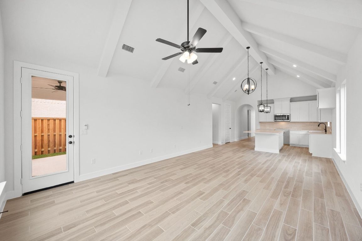 617 Buckaroo Drive Georgetown, TX 78633 - Photo 11 of 33 a view of a kitchen with wooden floor a sink a refrigerator and window