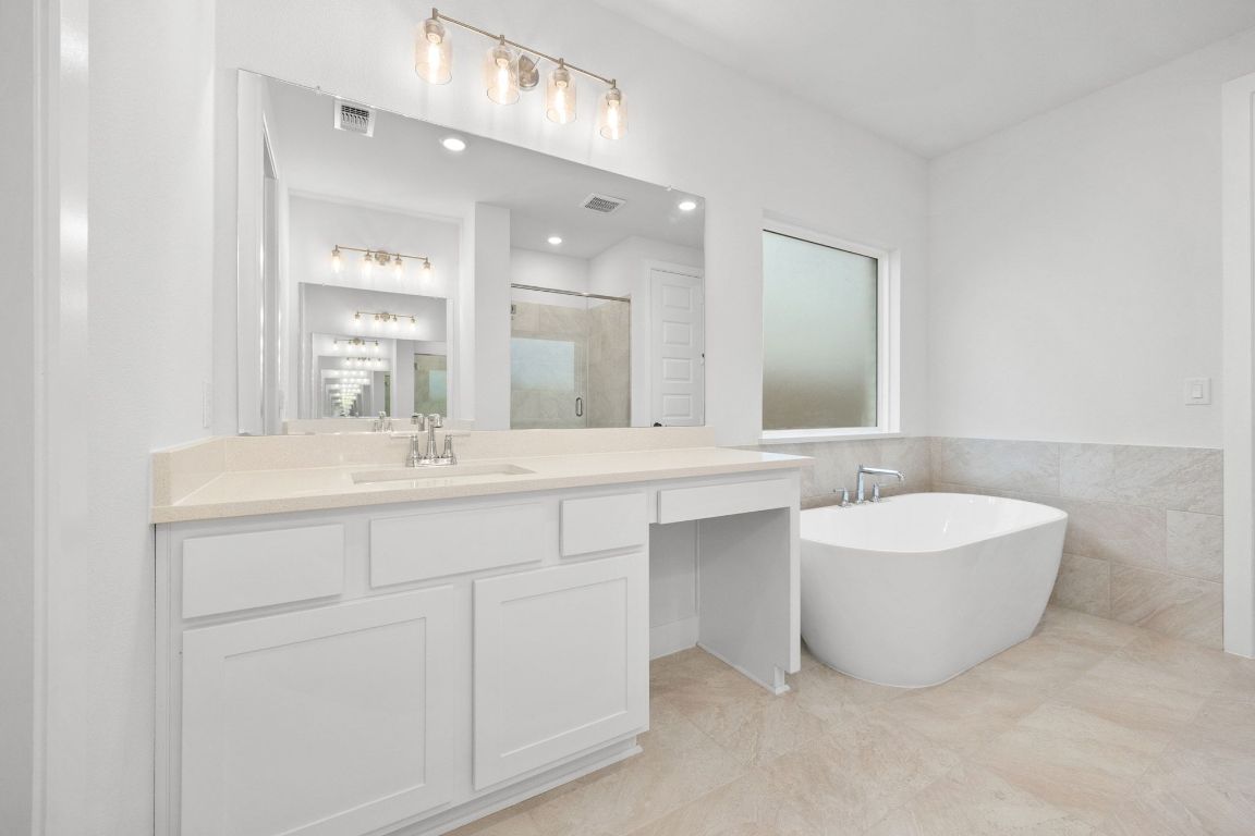 617 Buckaroo Drive Georgetown, TX 78633 - Photo 13 of 33 a bathroom with a double vanity sink mirror and bathtub
