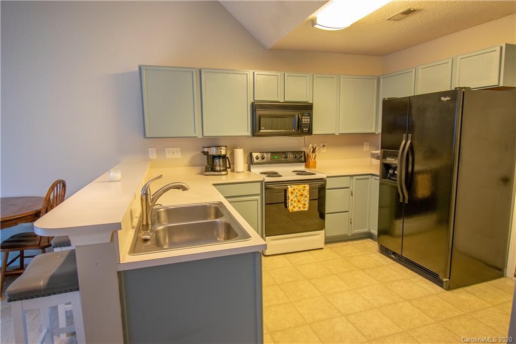 7016 Blithe Low Place Charlotte, NC 28273 - Photo 7 of 15 a kitchen with stainless steel appliances a stove a sink a refrigerator a microwave and cabinets
