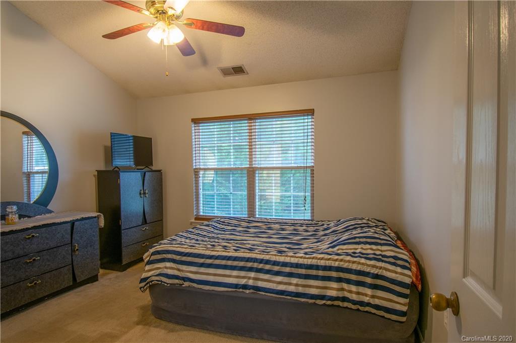 7016 Blithe Low Place Charlotte, NC 28273 - Photo 8 of 15 a bedroom with a bed and a mirror on the dresser