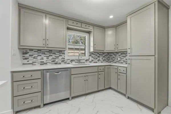 a kitchen with granite countertop white cabinets and sink