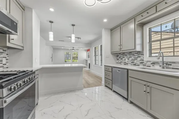 a kitchen with stainless steel appliances granite countertop a sink stove and cabinets