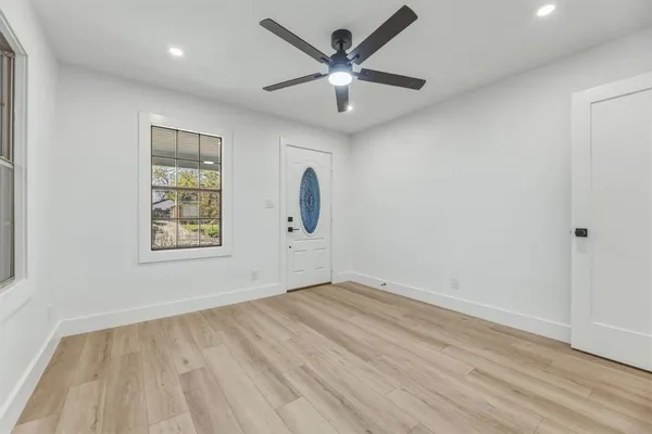 an empty room with wooden floor and windows