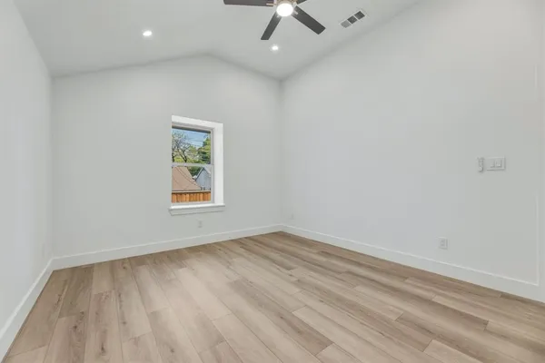 an empty room with a window and a ceiling fan