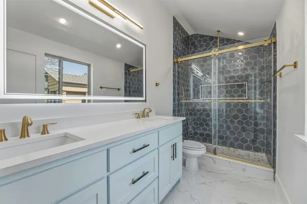 a bathroom with a double vanity sink toilet and shower